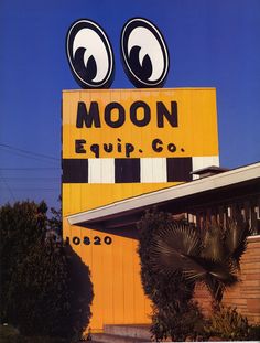 the moon equip co sign is painted yellow and has large eyes on it