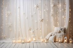 a living room with white curtains and stars on the wall, candles in front of it