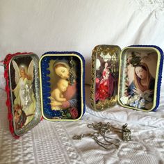 four small tins with angels in them sitting on a white bed next to a keychain