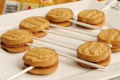 some cookies are on a white plate with toothpicks in the shape of letters