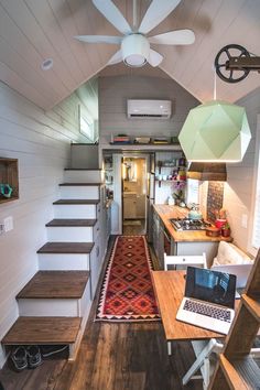 the interior of a tiny home with stairs leading up