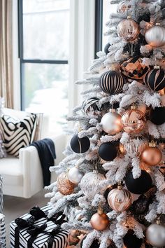 a white christmas tree with black and gold ornaments