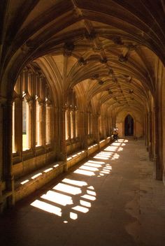 the sun is shining through the windows in an old building with stone arches and columns