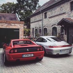 two cars parked next to each other in front of a brick building