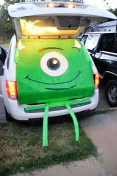 the back end of a green vehicle with eyes painted on it's trunk and hood