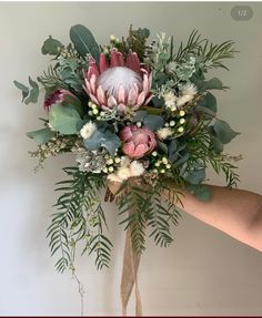 a bouquet of flowers is being held by someone's hand