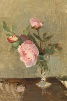 a painting of pink roses in a glass vase on a wooden table with other items