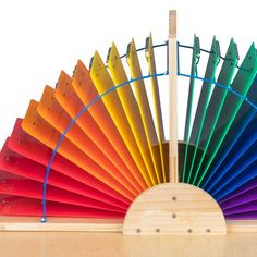 a rainbow colored fan sitting on top of a wooden table