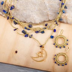 This pretty jewelry set from Alejandra Torres in Mexico features celestial blue shades complemented by gleaming gold. Multiple strands of crocheted golden metallic thread host polished chips of lapis lazuli to form the necklace which is centered by an 18k gold-plated brass moon and star pendant. The earrings are crafted from crocheted golden thread hoops that are accented with tiny lapis lazuli beads. The necklace clasp and earring hooks are 18k gold plated brass. Gold And Blue Jewelry, Moon And Star Pendant, Crocheted Jewelry, Aqua Earrings, Celestial Blue, Necklace Clasp, Golden Thread, Lapis Lazuli Jewelry, Lapis Lazuli Beads