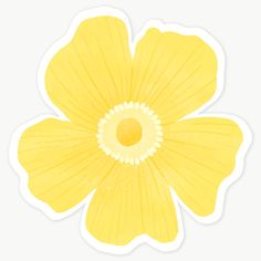 a yellow flower sticker sitting on top of a white surface with the petals open