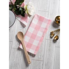 a pink and white checkered kitchen towel next to utensils