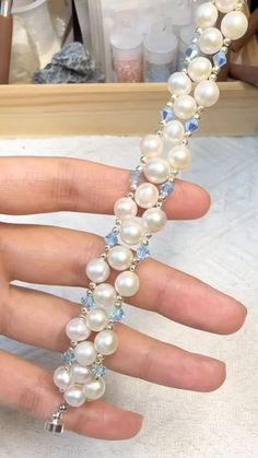 a woman's hand with a bracelet made out of pearls and swarong crystals