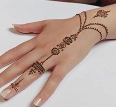 a woman's hand with henna tattoos on it