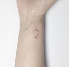 a small tattoo on the wrist of a woman's arm, with a cat