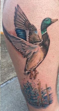 a tattoo on the leg of a man with a duck