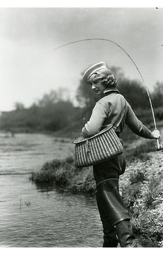 an old black and white photo of a man fishing