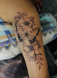 a woman's arm with flowers and butterflies tattoo on the left side of her leg