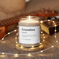 a candle sitting on top of a table next to a string of lights and a guitar