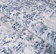 a blue and white floral print fabric with an intricate design on the bottom half of it