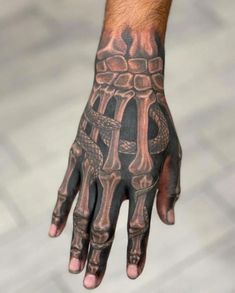 a man's hand with tattoos on it