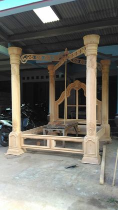 a wooden bed frame sitting in the middle of a garage with scaffolding around it