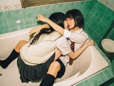 two girls in a bathtub with their arms around each other