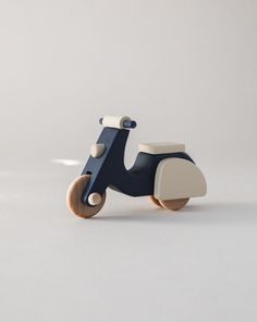 a wooden toy scooter sitting on top of a white table