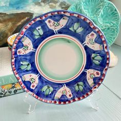 a blue and white plate sitting on top of a table next to a stack of books