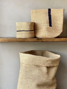 two baskets sitting on top of a wooden shelf