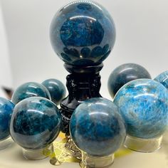 several blue marbled objects are arranged on a white surface, including one large ball and six smaller balls