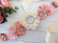 pink and white flowers are sitting on a table next to some ribbons with the word happy birthday written on them