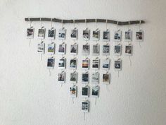 a bunch of pictures hanging on a wall with clothes pins attached to them and string