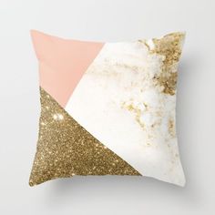 a pink and gold pillow with glitter on the bottom, in front of a white background