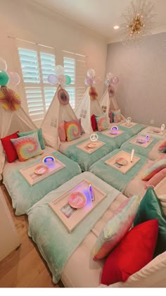 two beds with pillows and pictures on them in a room that is decorated with balloons