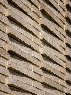 the side of a building made out of bricks and concrete blocks with small holes in them