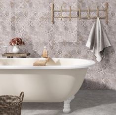 a white bath tub sitting next to a wall with a towel rack on top of it