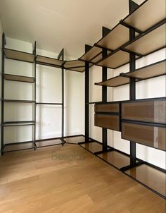 an empty room with shelves and wooden floors