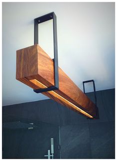 the light fixture is made from wood and has metal bars on each end, along with leds