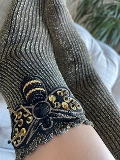 Step into a world of comfort and style with our Handmade Cotton Socks, featuring an exquisite gold and black bee embellishment. Crafted with 75% cotton, 23% polyester, and 2% elastane, these one-size socks offer the perfect blend of durability and stretch for everyday wear. Our unique mesh design, adorned with crystal-like stones and intricate bee embroidery, injects a touch of elegance and whimsy into any ensemble. Designed for the fashion-forward individual, these socks merge trendiness with t Honeycomb Socks, Bee Embellishment, Big Bee, Black Bee, Womens Socks, Mesh Socks, Bee Embroidery, Stylish Socks, Style Savvy