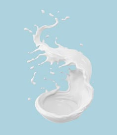 milk splashing into the air on a blue background