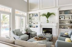 a living room filled with furniture and a fire place in front of a large window