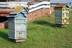 two small wooden houses sitting in the grass