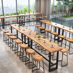 an empty restaurant with tables and stools in front of large windows overlooking the city