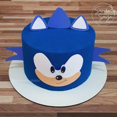 a blue cake with an angry face and ears on it's top is sitting on a white plate