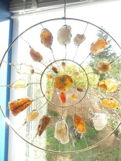 a wind chime hanging in front of a window with lots of sea glass on it