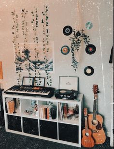 there is a record player and other musical instruments on the shelf in front of the wall