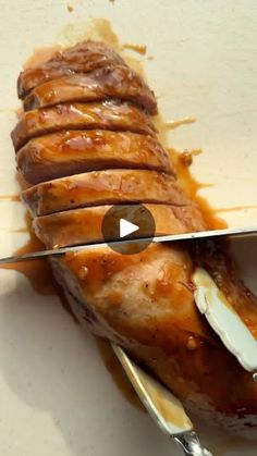 a knife cutting into some food on top of a white plate