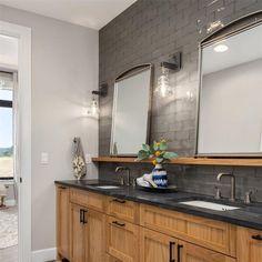 a bathroom with two sinks and mirrors in it