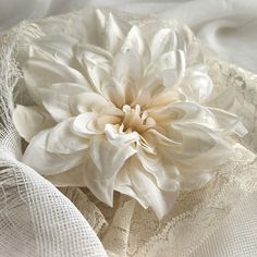 a large white flower sitting on top of lace