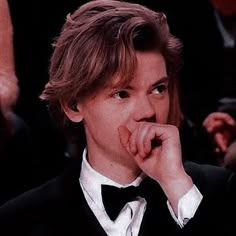 a young man wearing a tuxedo and bow tie